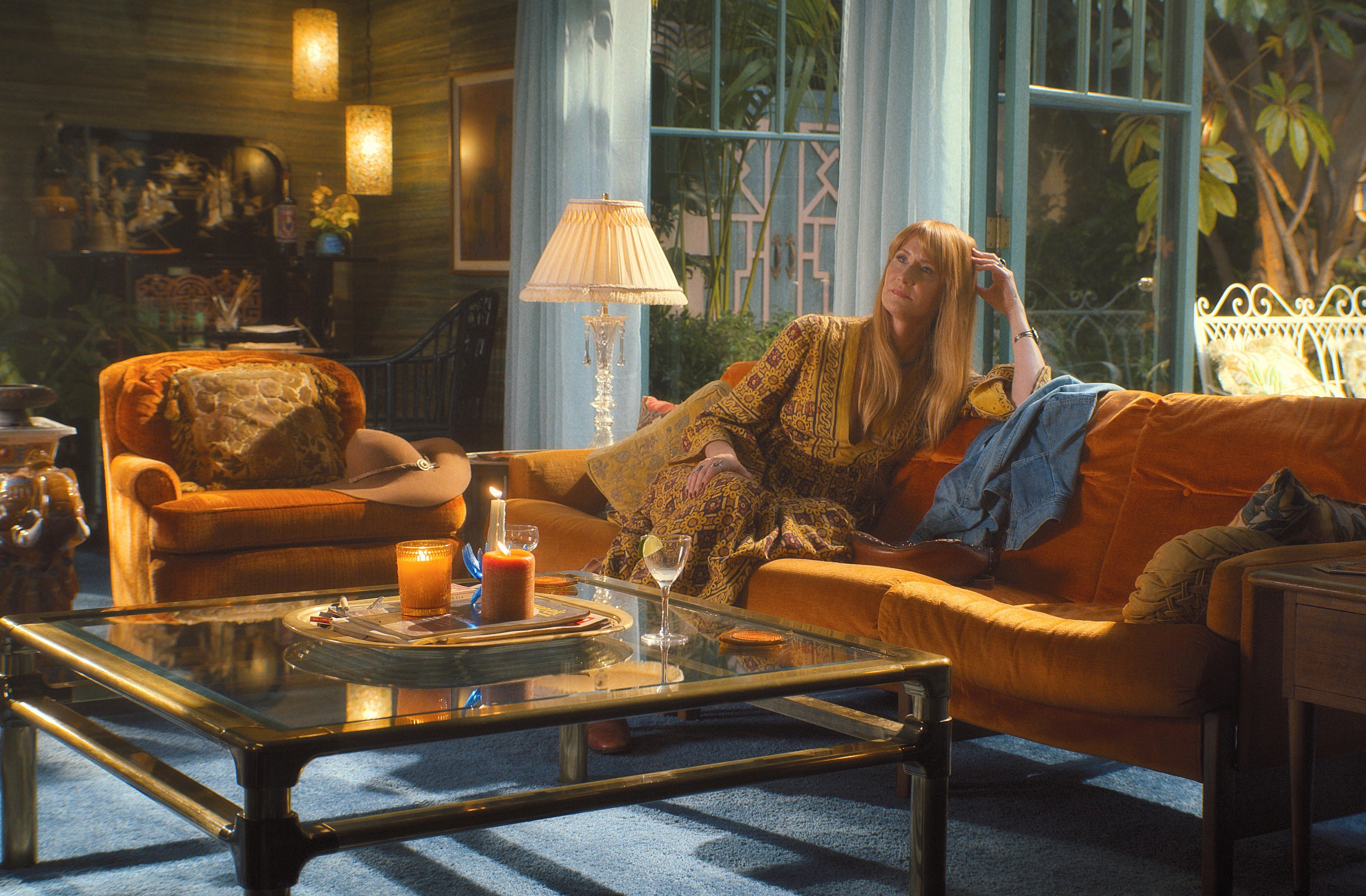 Laura Dern in Palm Royale sitting on a couch