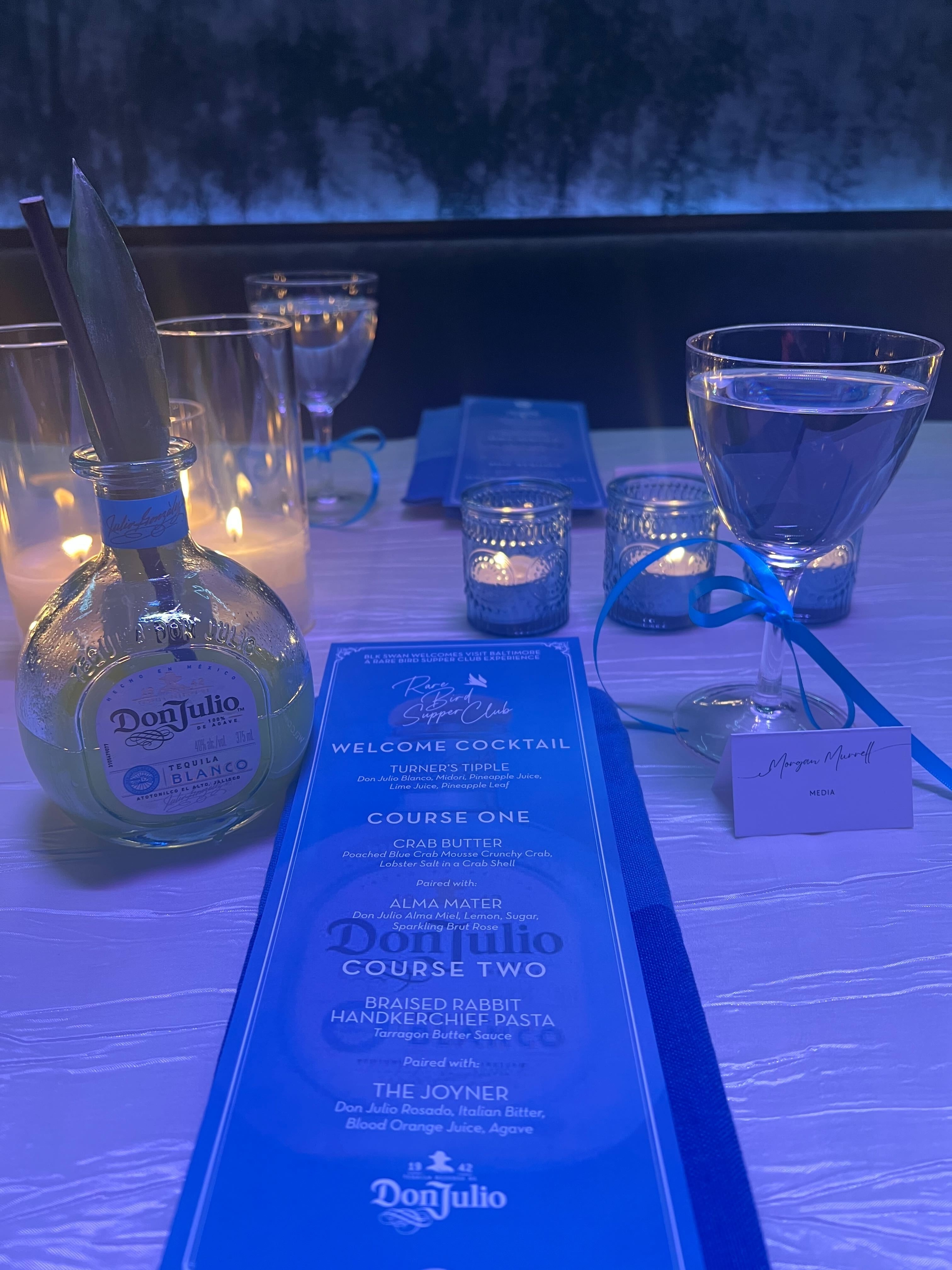 Bottle of Don Julio and a welcome cocktail menu on a table with a place card