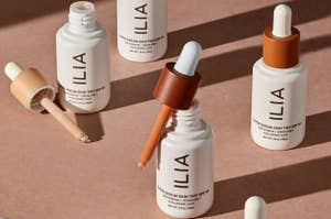 Ilia beauty serum skin tint bottles with droppers on a flat surface