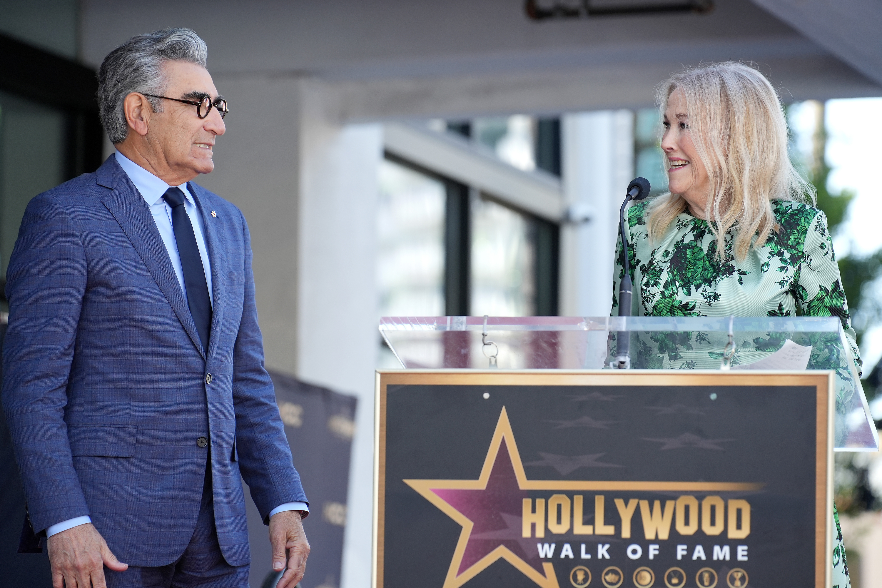 Eugene Levy and Catherine O&#x27;Hara at a Hollywood Walk of Fame ceremony, standing by a podium with a star plaque