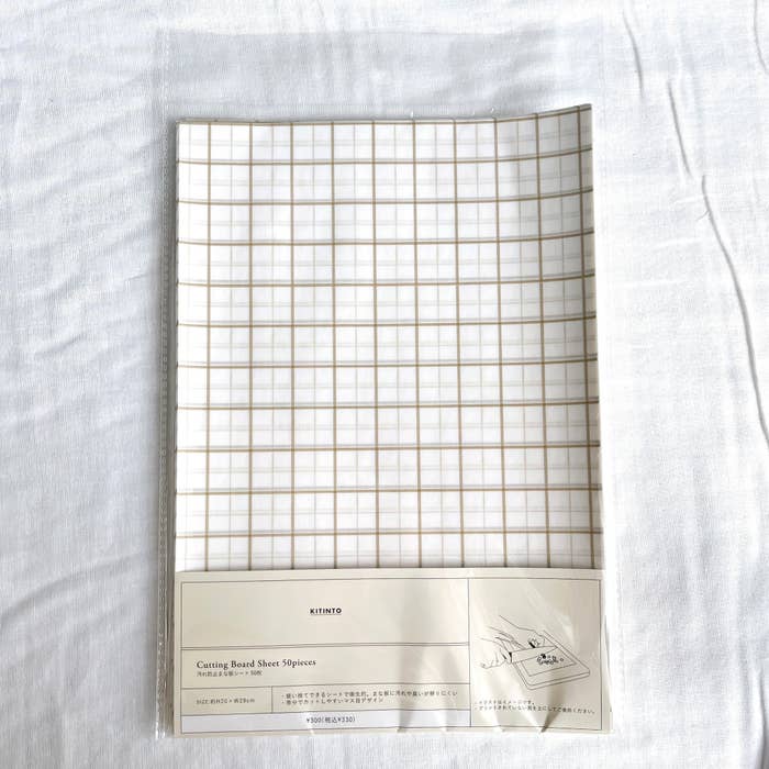 3COINSのオススメのグッズ「汚れ防止まな板シート：50枚入り／KITINTO」
