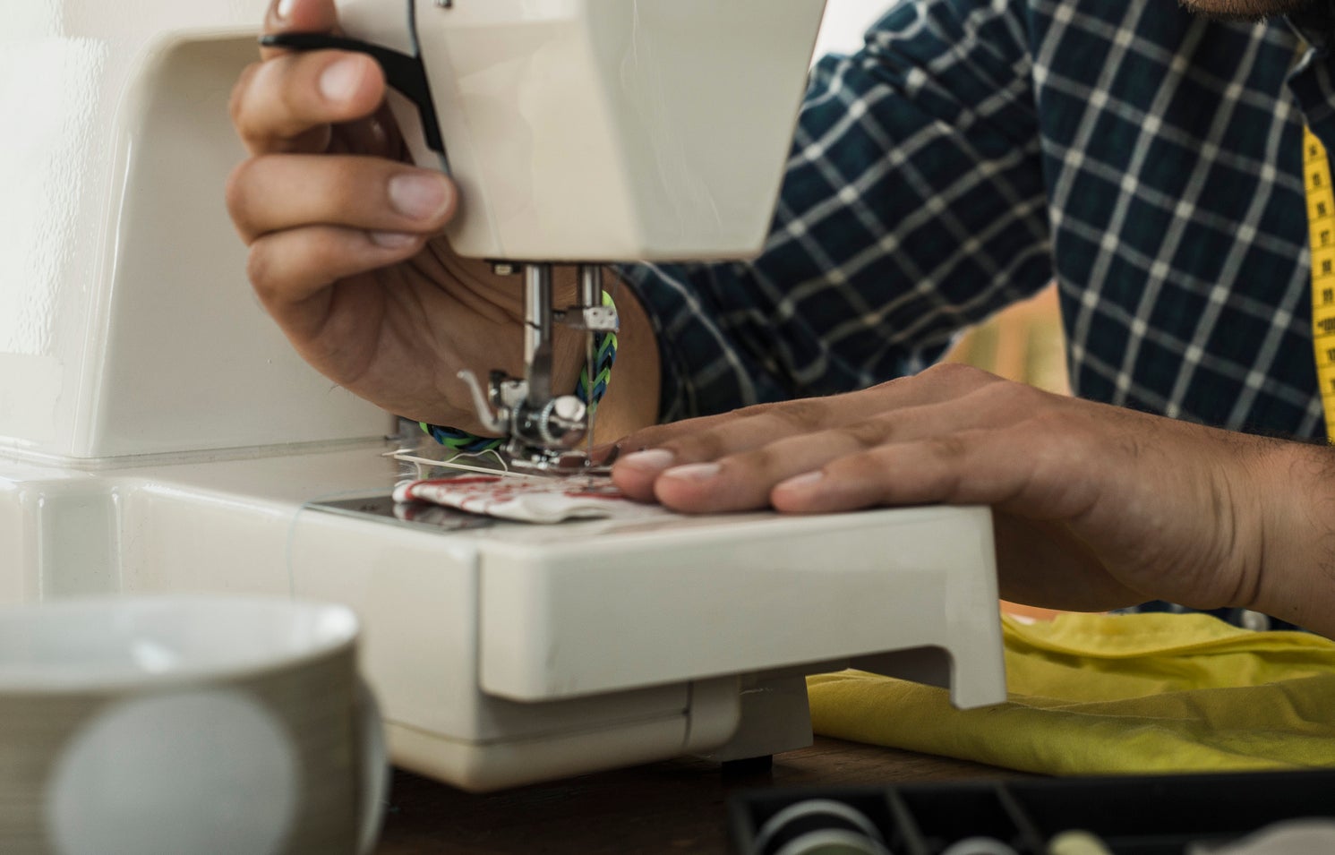Person using a sewing machine, focused on stitching fabric