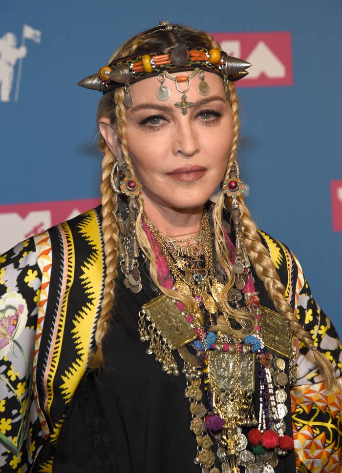 Madonna wearing a patterned jacket and accessorized with layered necklaces and headpiece