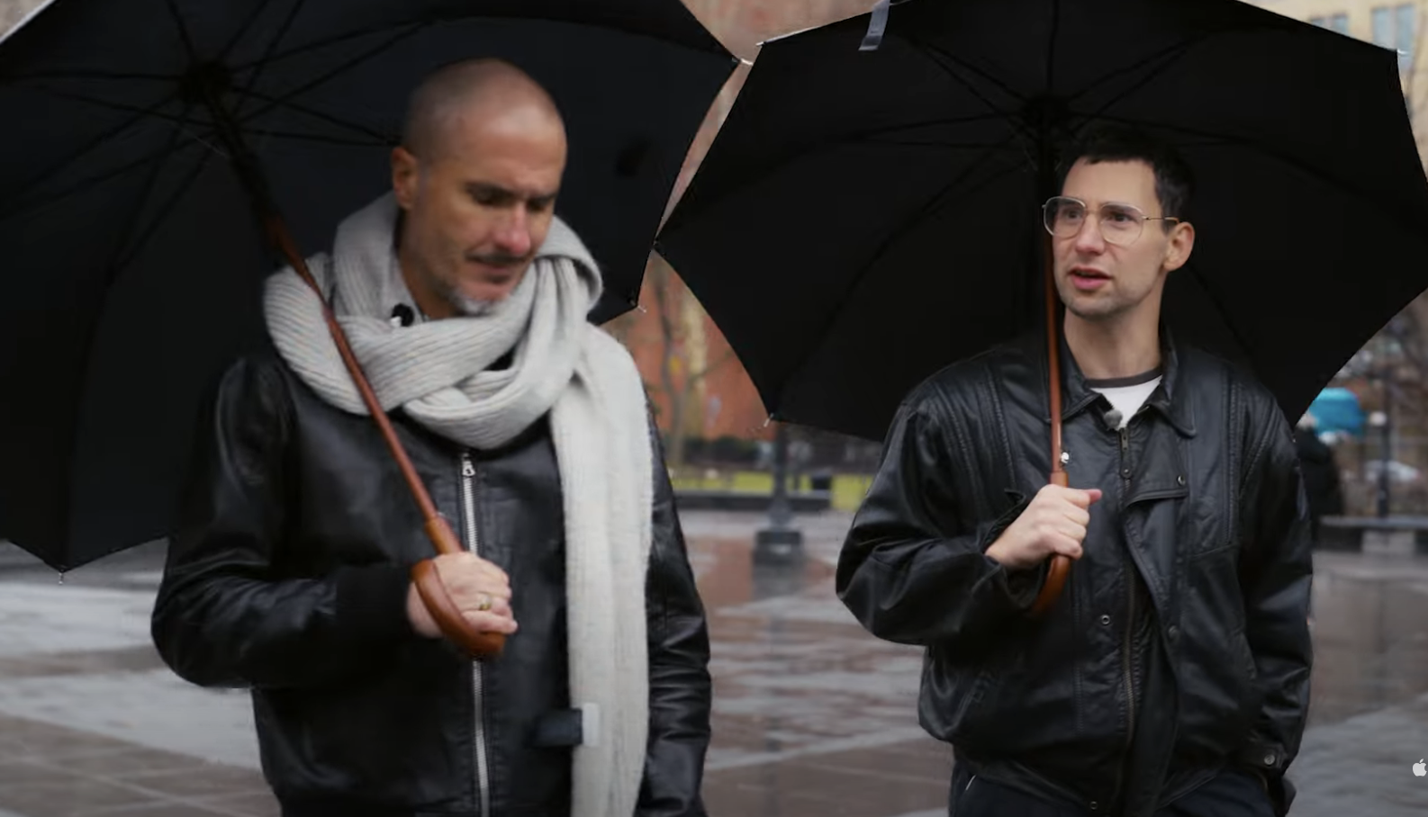 Zane and Jack walking outside under umbrellas