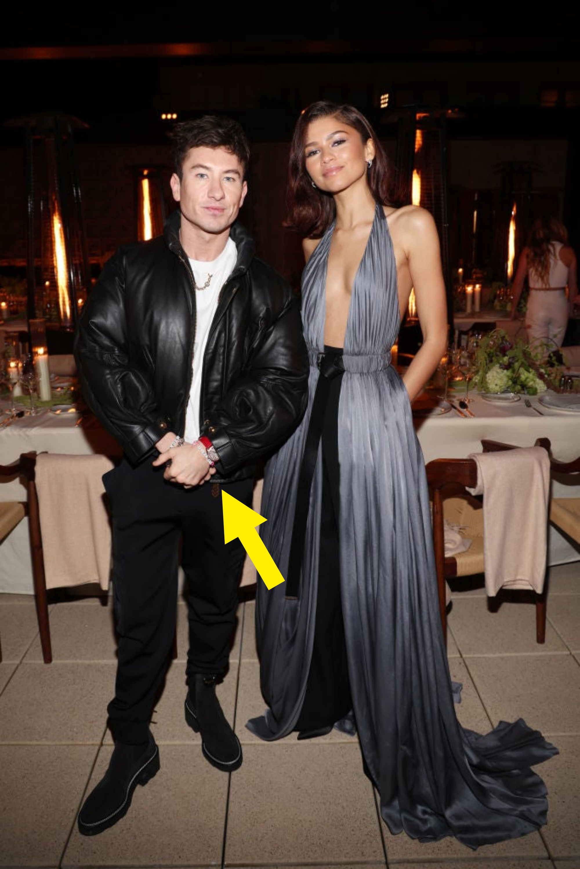 zendaya is in a plunging neckline gown as she poses next to him