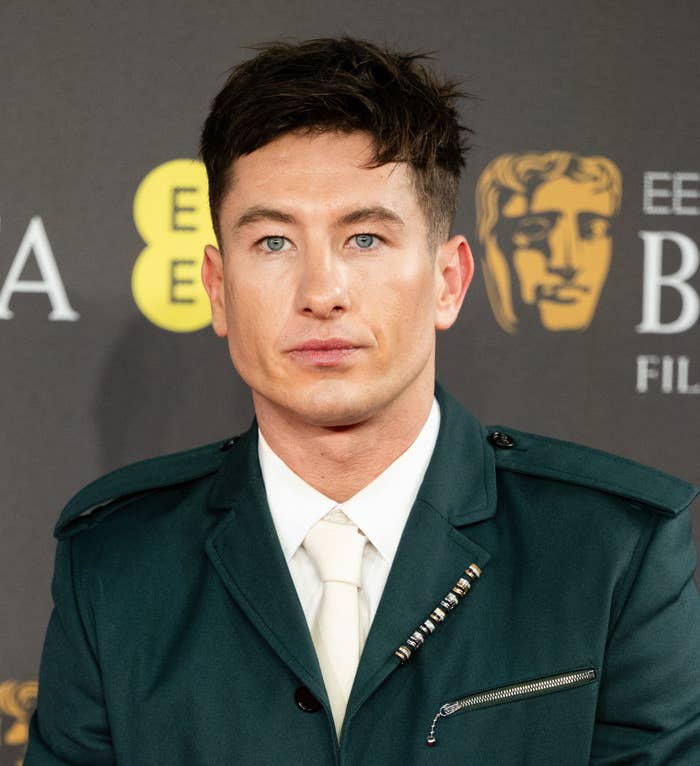 Barry Keoghan at an event, wearing a double-breasted suit jacket with shoulder straps