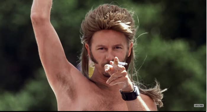 closeup of joe dirt with a mullet, shirtless, and cigarette in hand
