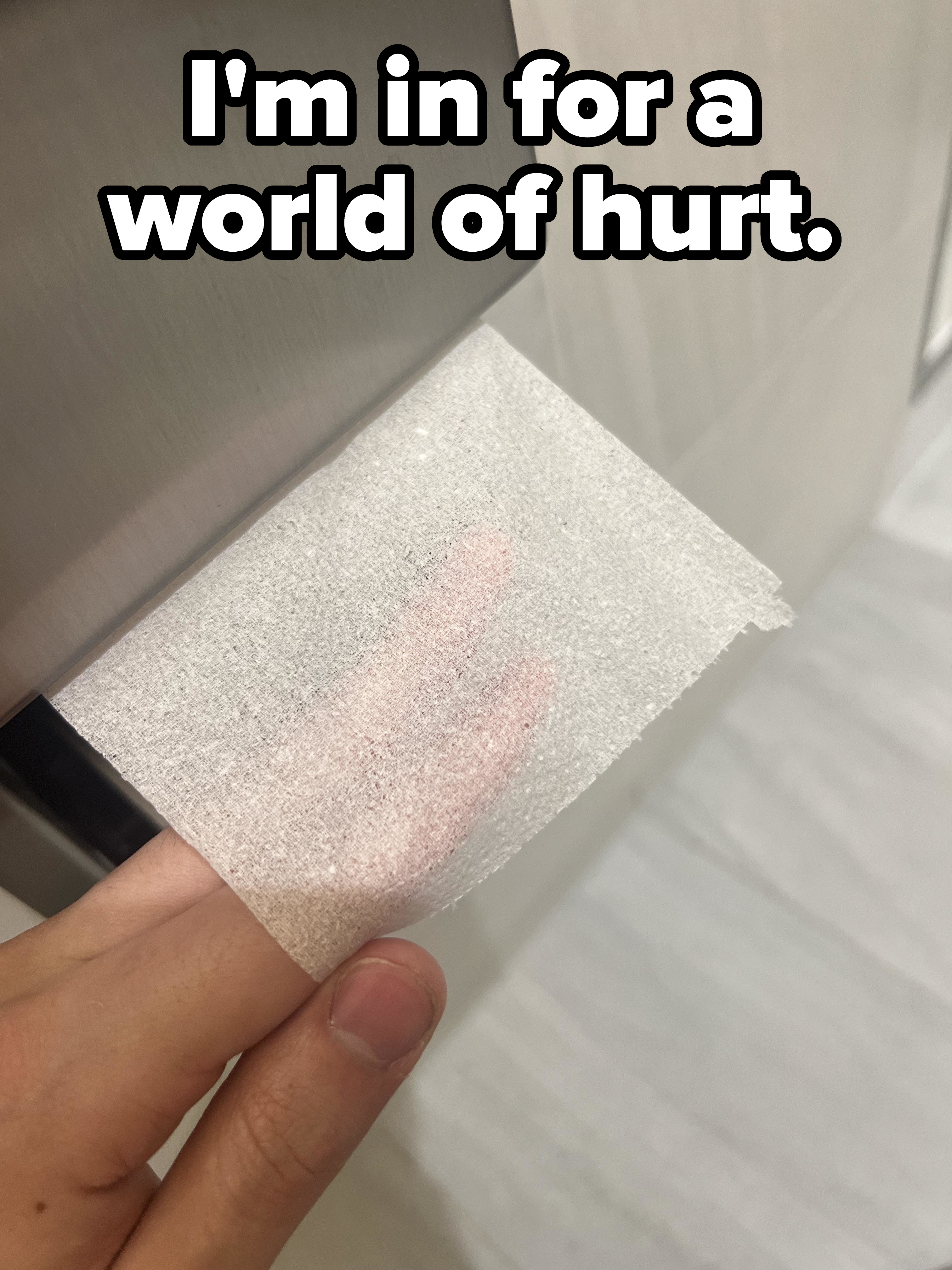 Hand holding a square of very thin toilet paper with the fingers of the hand holding it visible through it