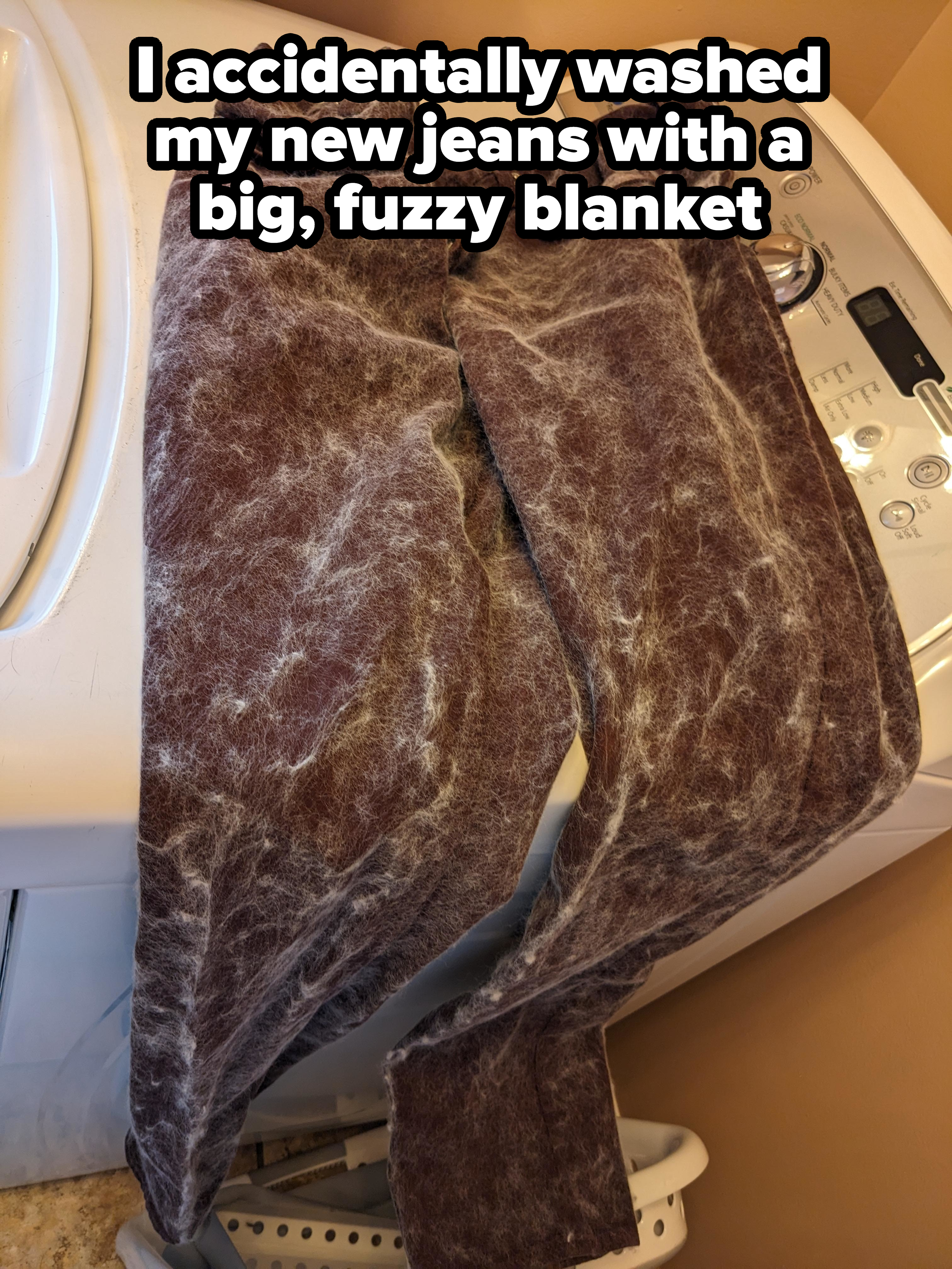 A pair of heavily lint-covered pants on a washing machine