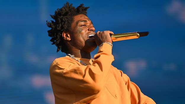 Musician in orange attire performing with a microphone