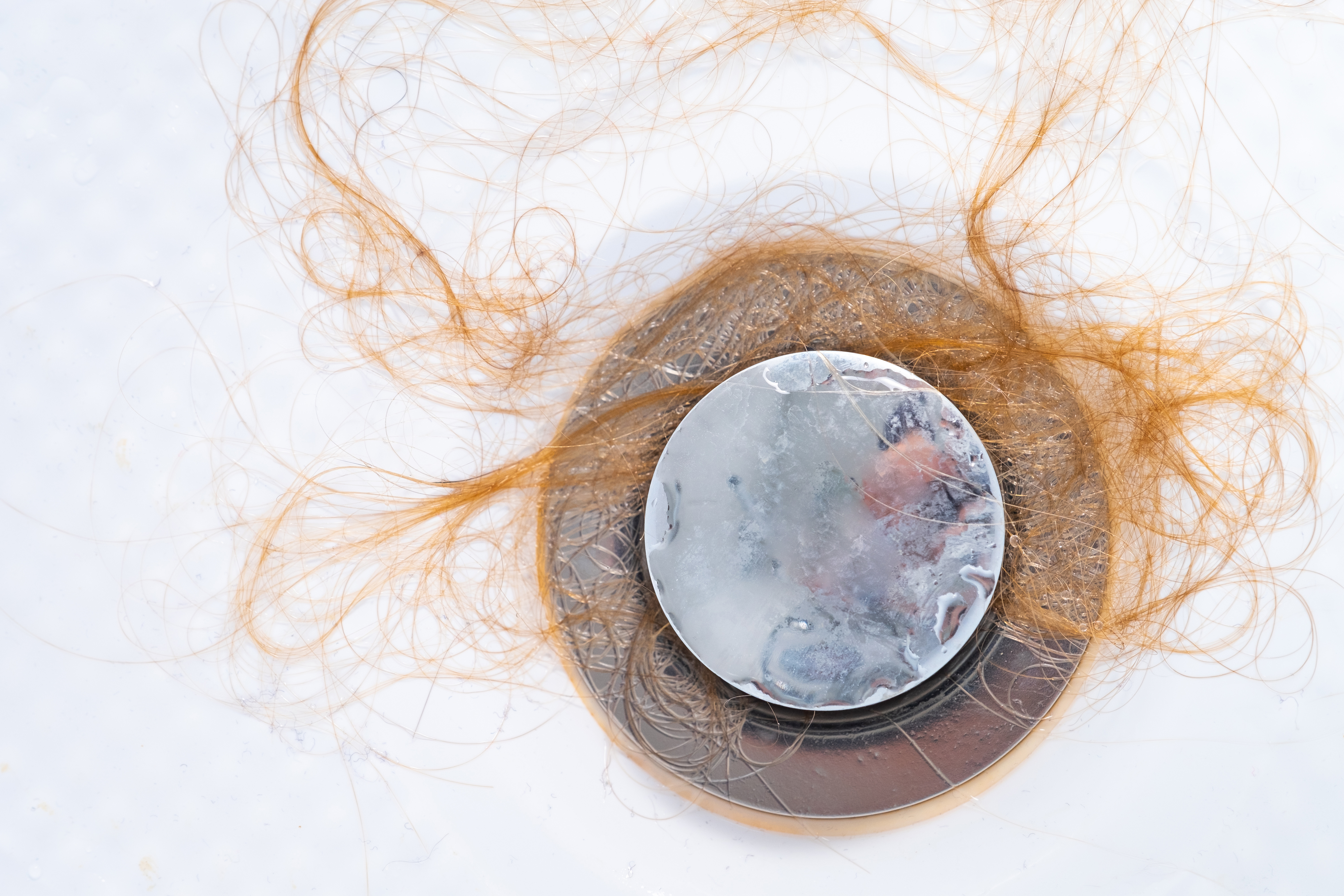 A frozen condom surrounded by strands of hair, suggestive of sexual themes related to cold temperatures or problems
