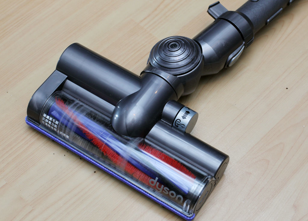 Dyson vacuum cleaner head on a wooden floor