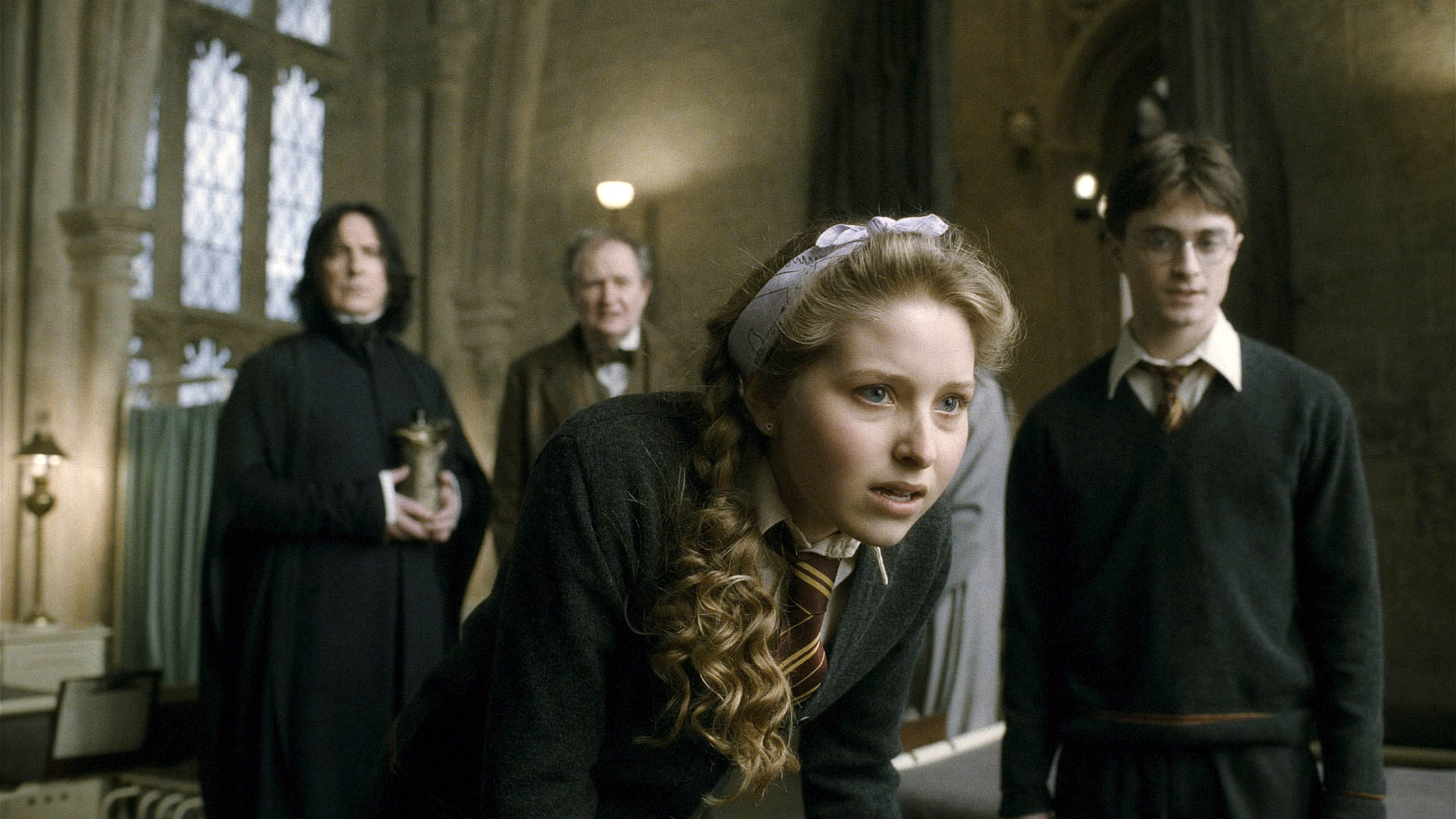 Snape, Lupin, Lavender, and Harry stand in the Hogwarts classroom, expressing concern