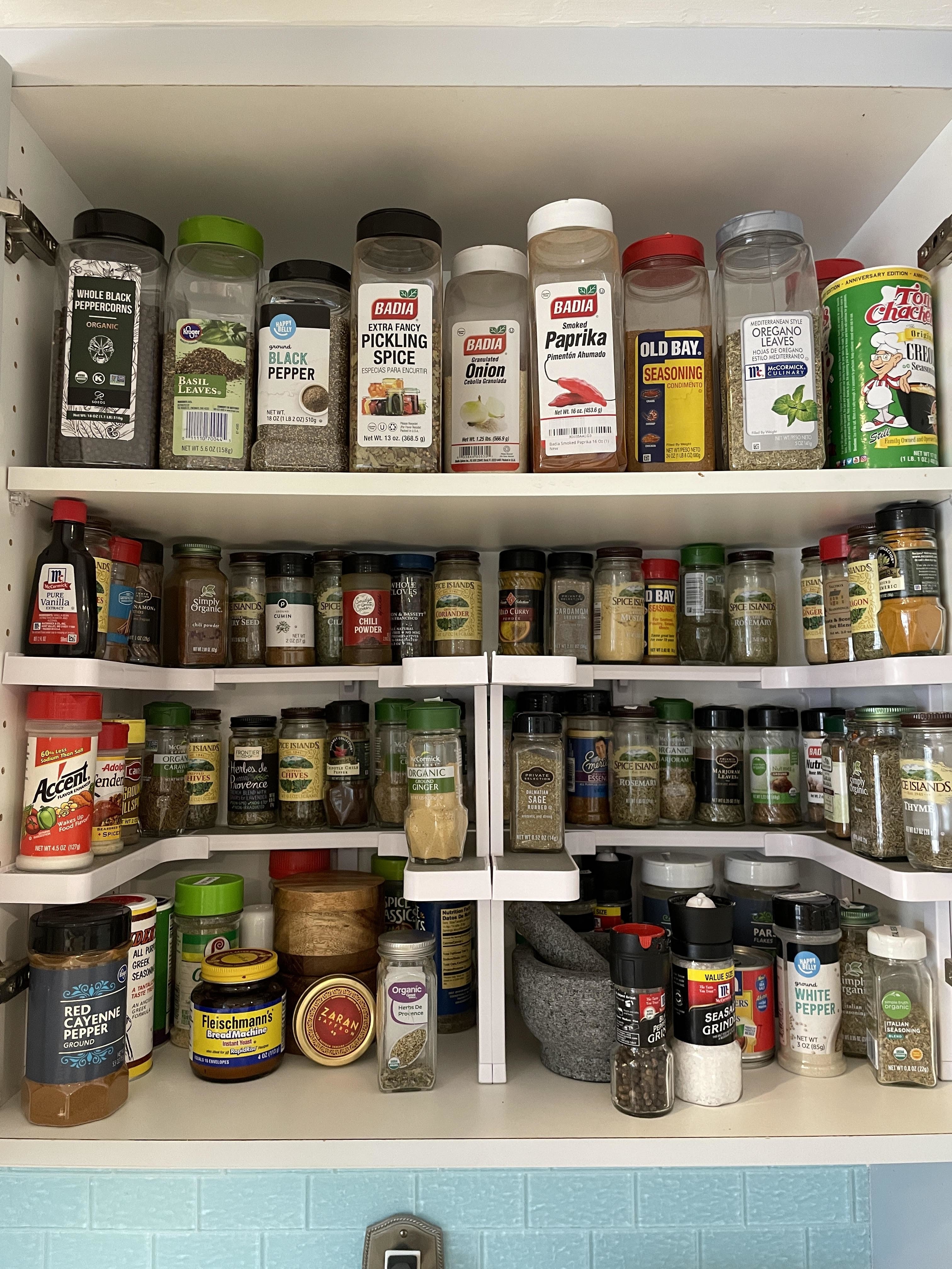 A neatly organized spice rack with various labeled seasoning containers