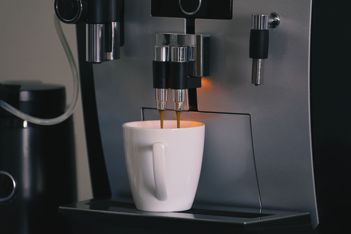 Espresso pouring into a white cup from a coffee machine, showcasing a modern kitchen appliance