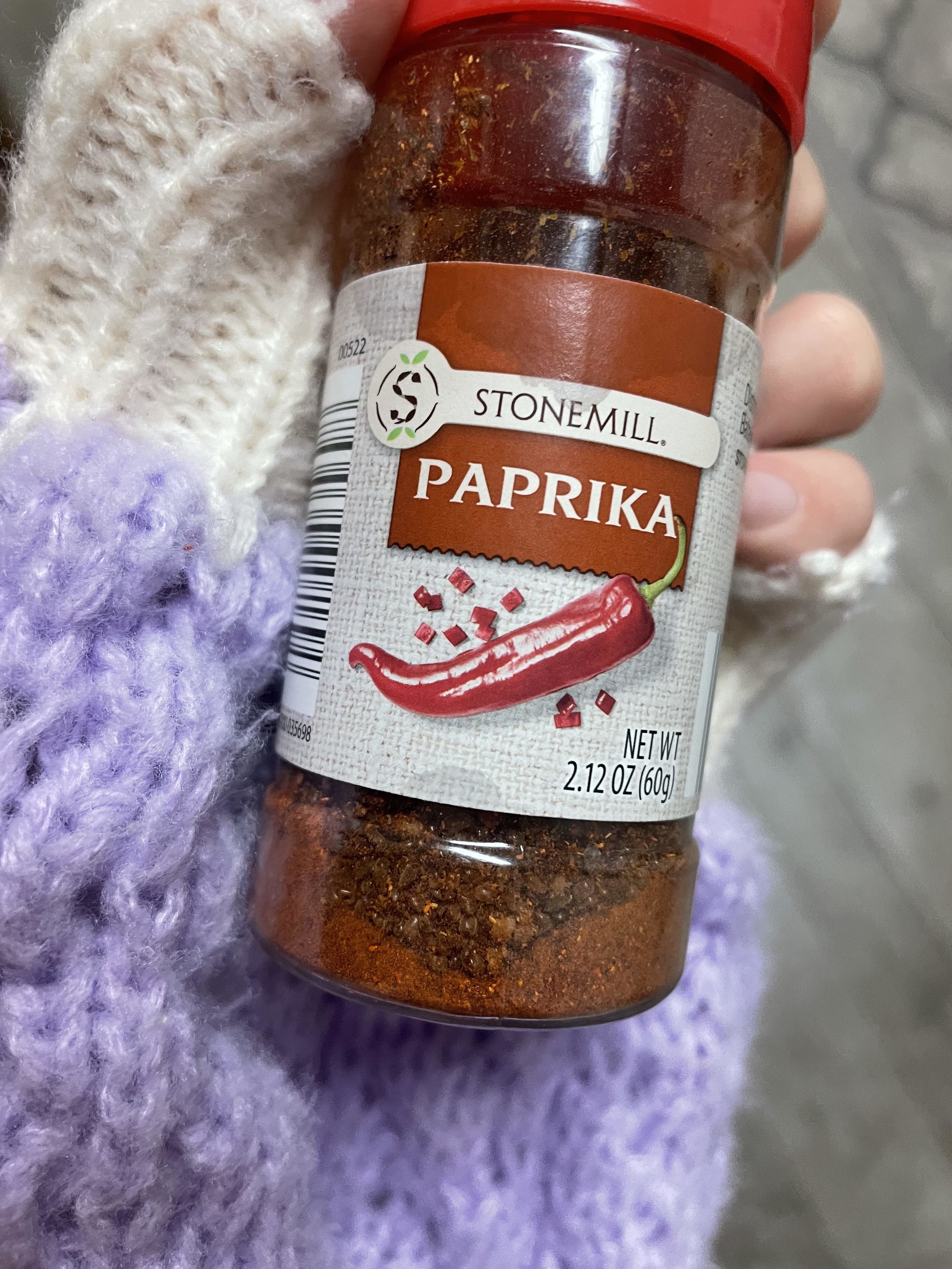 Hand holding a Stonemill Paprika spice jar