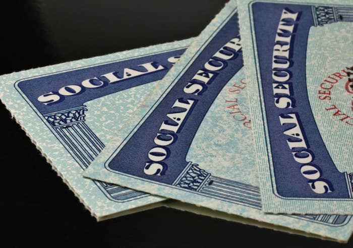 Two U.S. Social Security cards overlapping on a dark surface