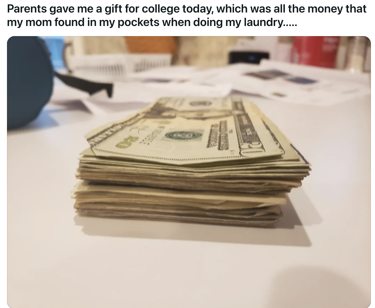 Stack of various bills on a table, presented as a gift from parents for college funds