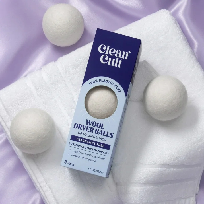Box of Clean Cult wool dryer balls on a towel with three balls displayed around it