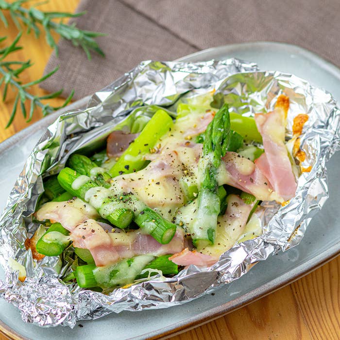 アルミホイルで包まれたアスパラガスとベーコンの料理。