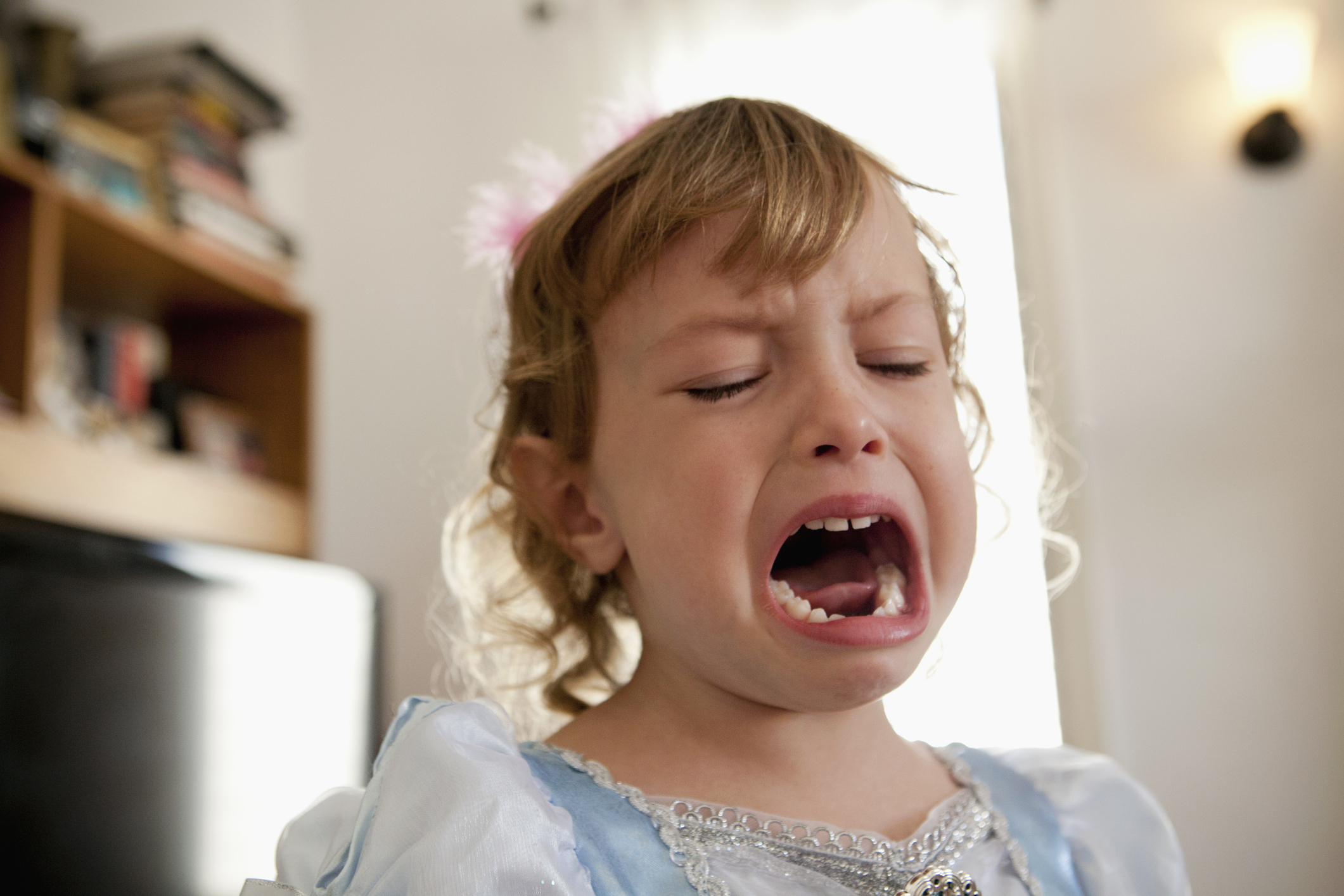 Young child in princess costume is crying