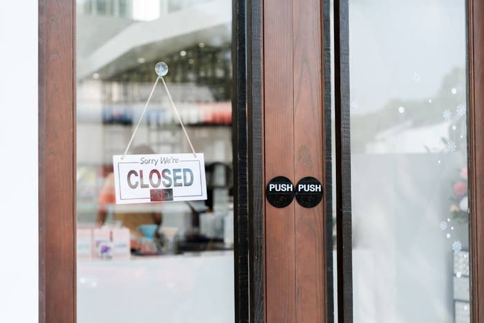 Sign on a store door reads &quot;Sorry We&#x27;re Closed.&quot;