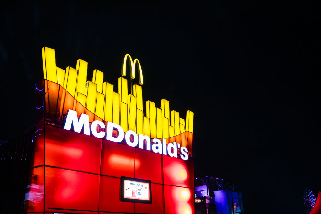Neon-lit McDonald&#x27;s sign with iconic golden arches at night