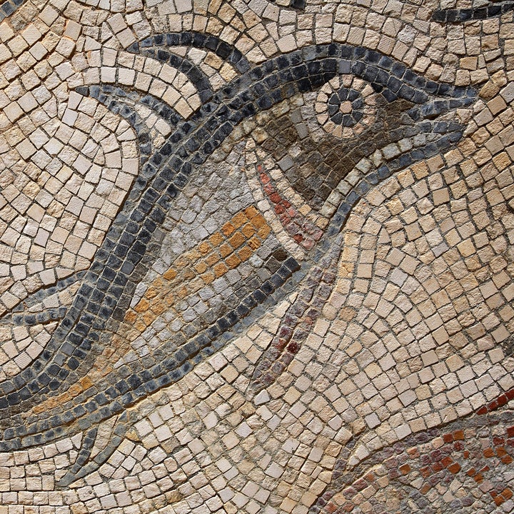 Ancient mosaic of a dolphin, with intricate stone tile design
