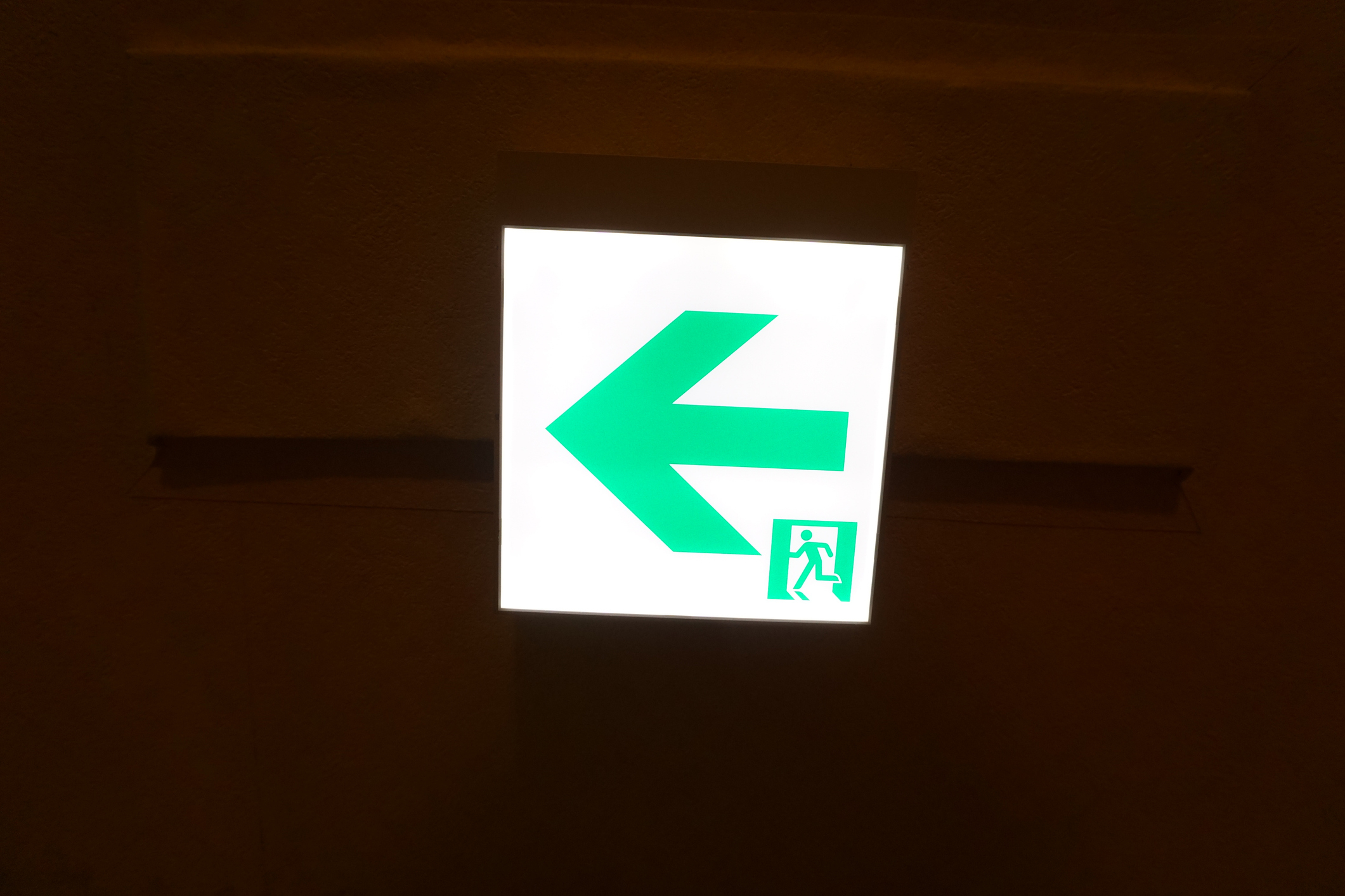 緑色の矢印と「出口」と書かれた非常口の標識。