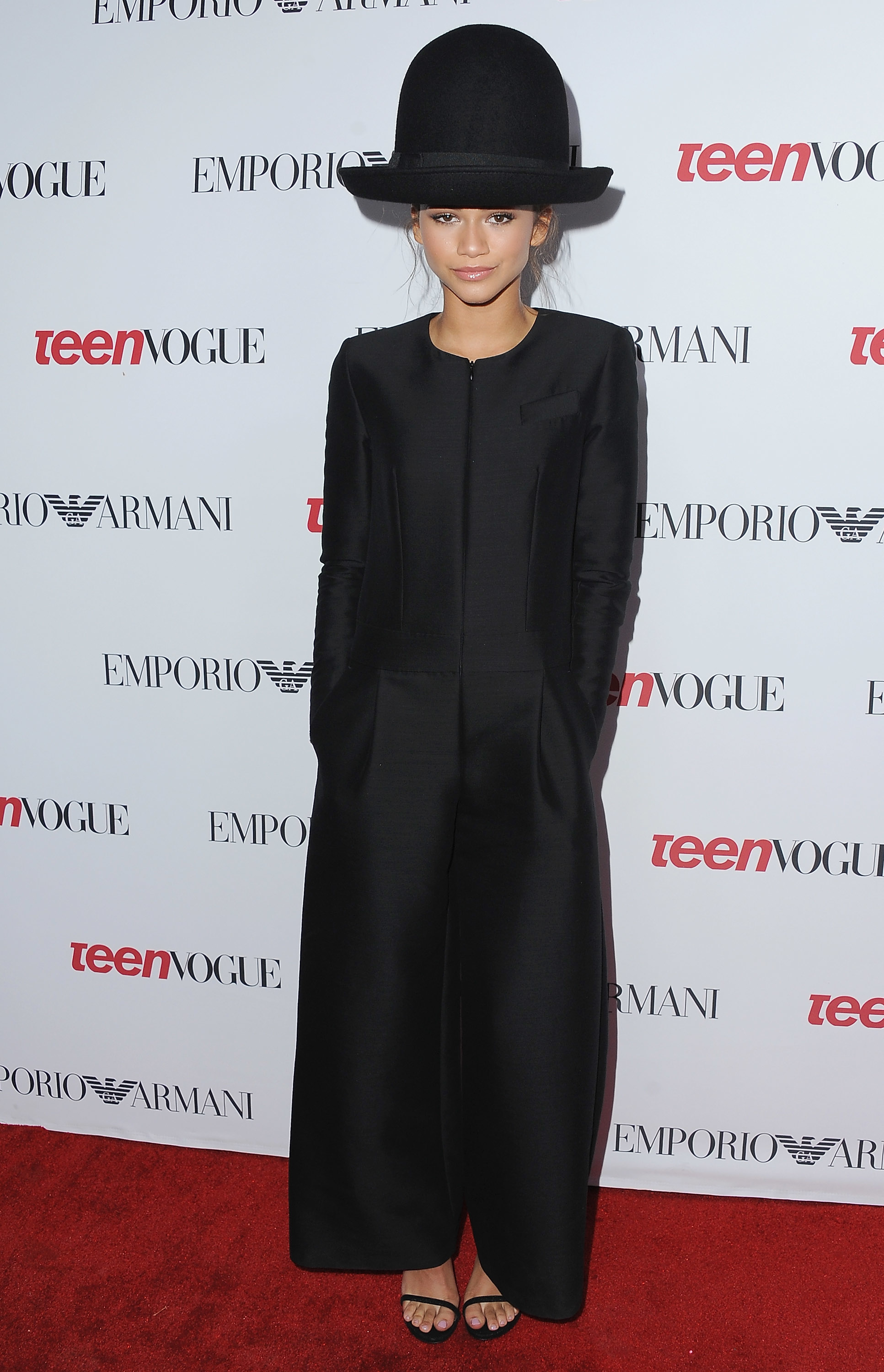 Person in a wide-brimmed hat and tailored black outfit at a fashion event