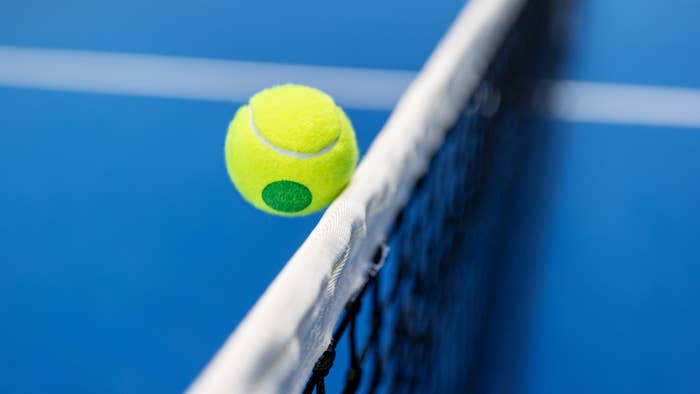 Close-up of a tennis ball above the net on a tennis court