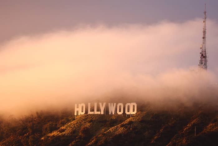 Hollywood sign partially obscured by mist with broadcast tower in the background