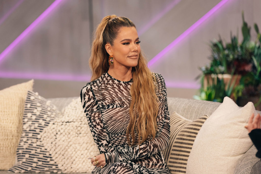 Khloé in patterned dress sitting on a couch during a talk show