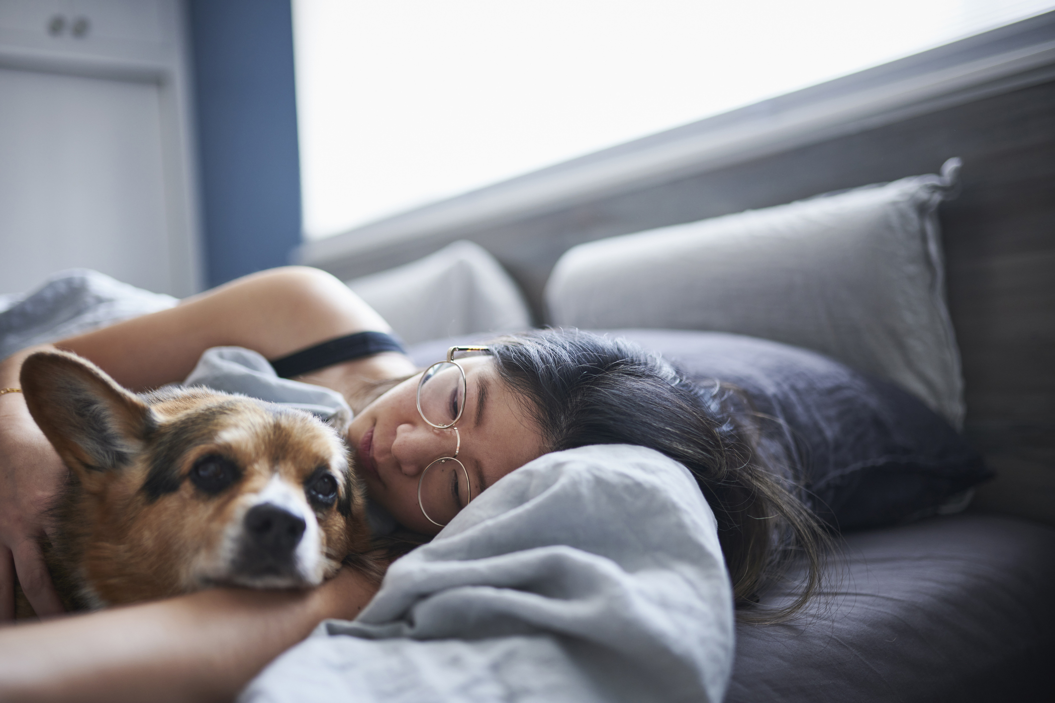 Woman resting in bed with her dog