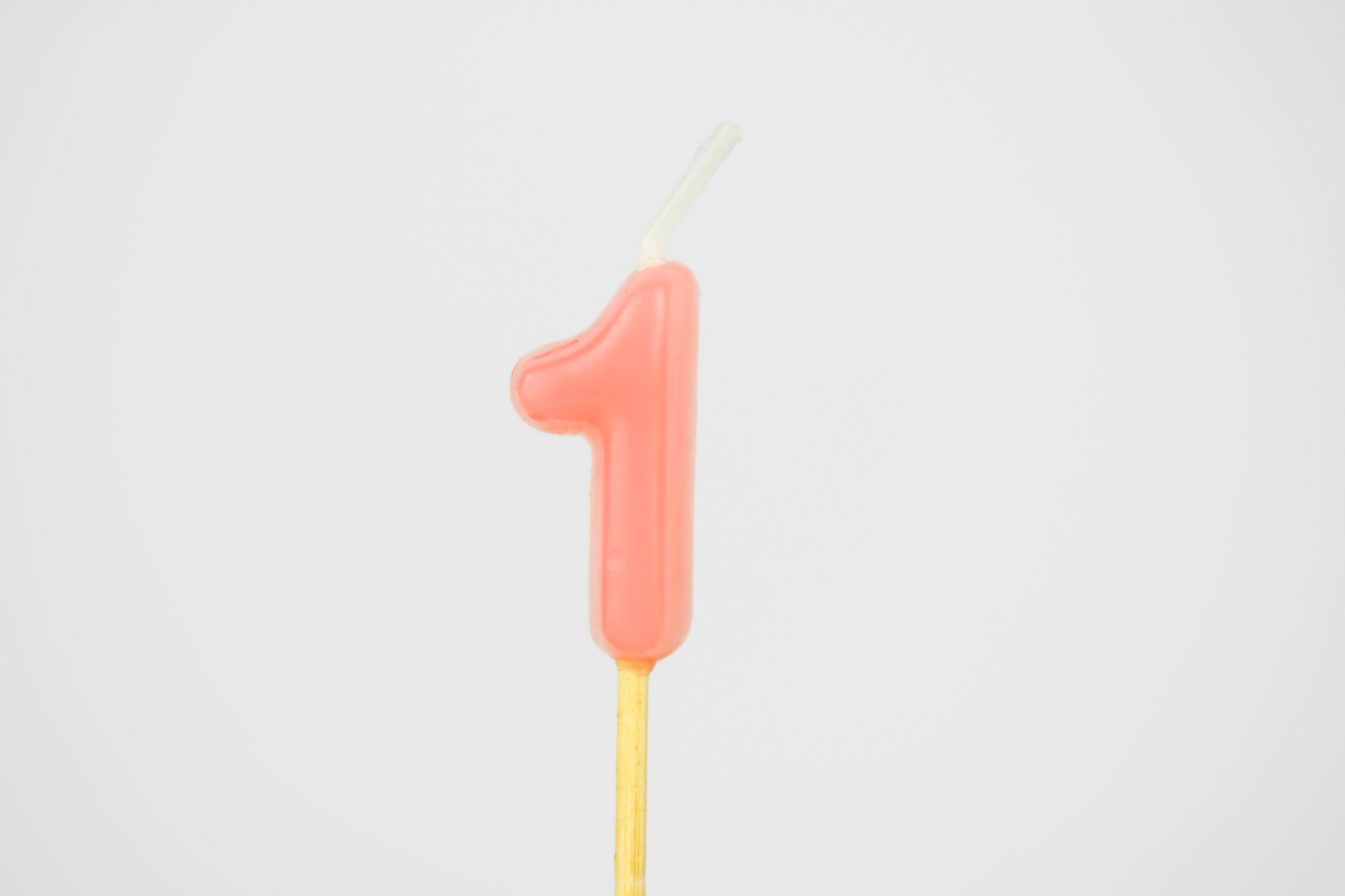 candle shaped like number one on a neutral background