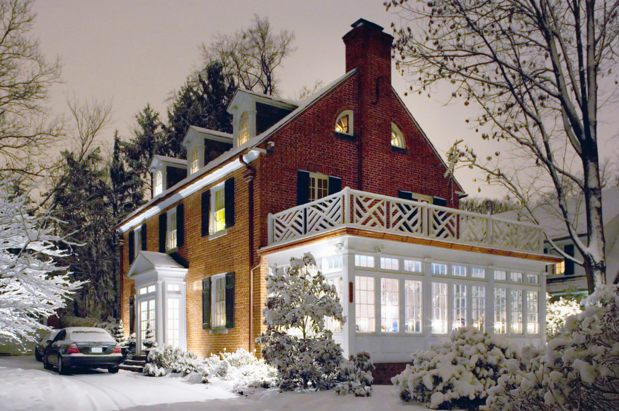 a suburban brick home covered in snow at night