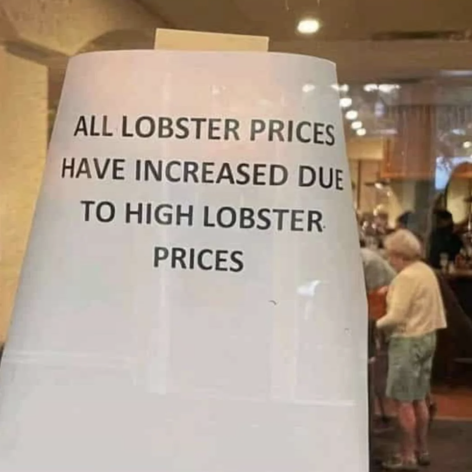 Sign reads &quot;ALL LOBSTER PRICES HAVE INCREASED DUE TO HIGH LOBSTER PRICES,&quot; with a person in the background