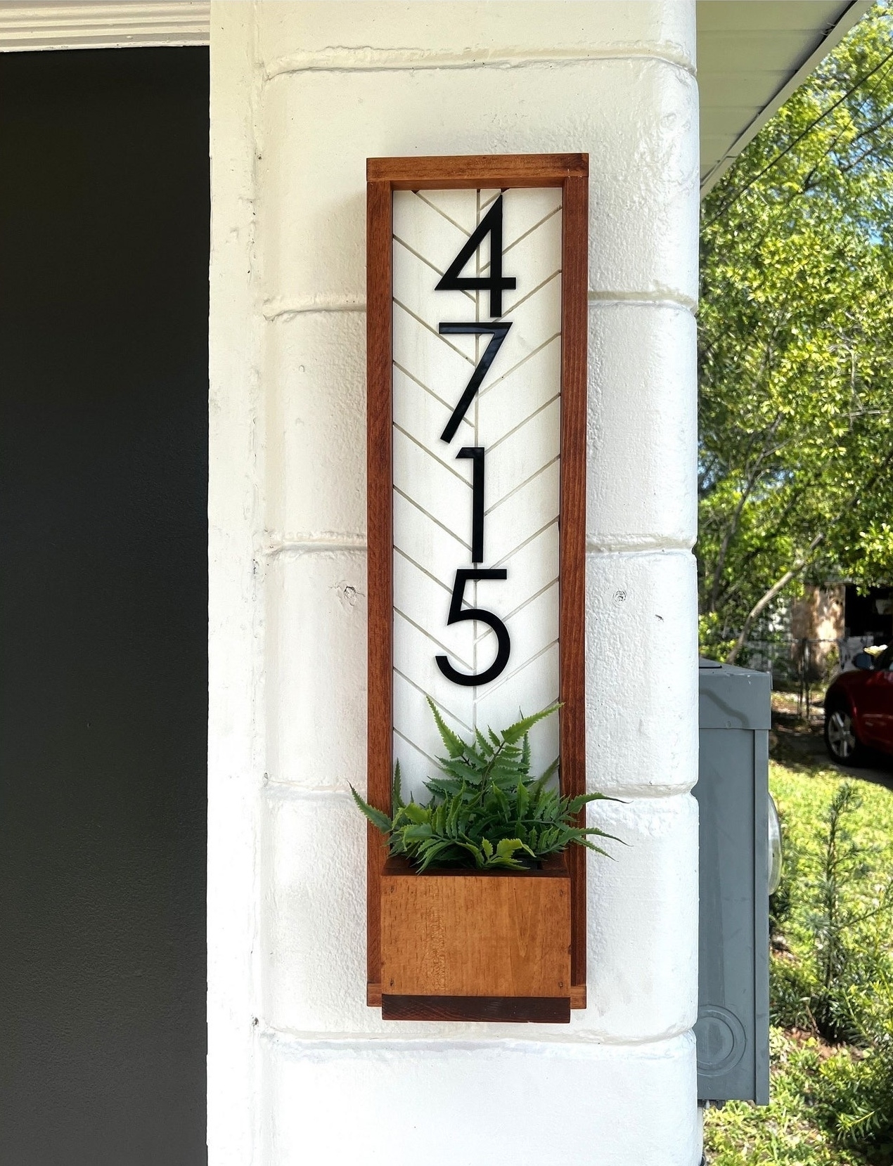 House number sign with large numerals and a built-in planter beneath the numbers