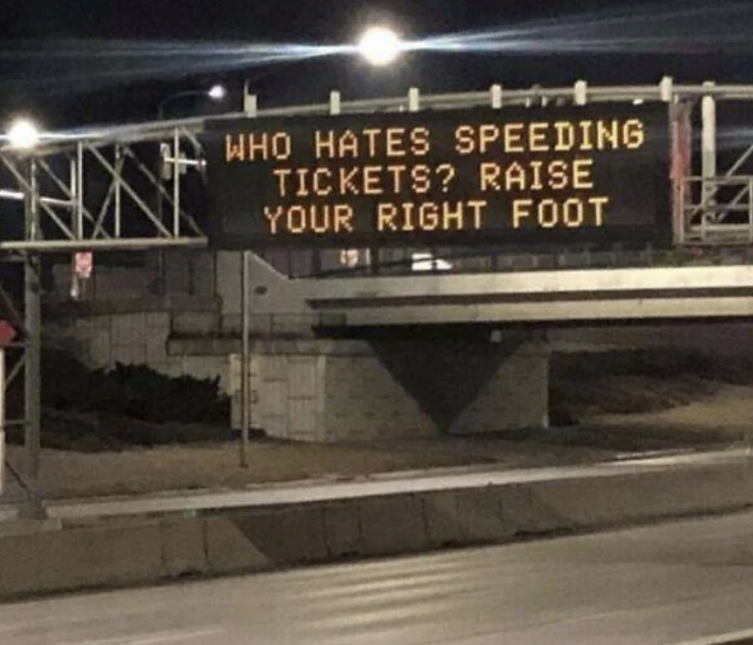 Electronic roadside sign with text asking drivers who dislike speeding tickets to raise their right foot