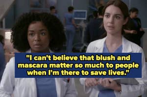 Two female TV show characters in medical attire, one speaking about the triviality of makeup versus saving lives