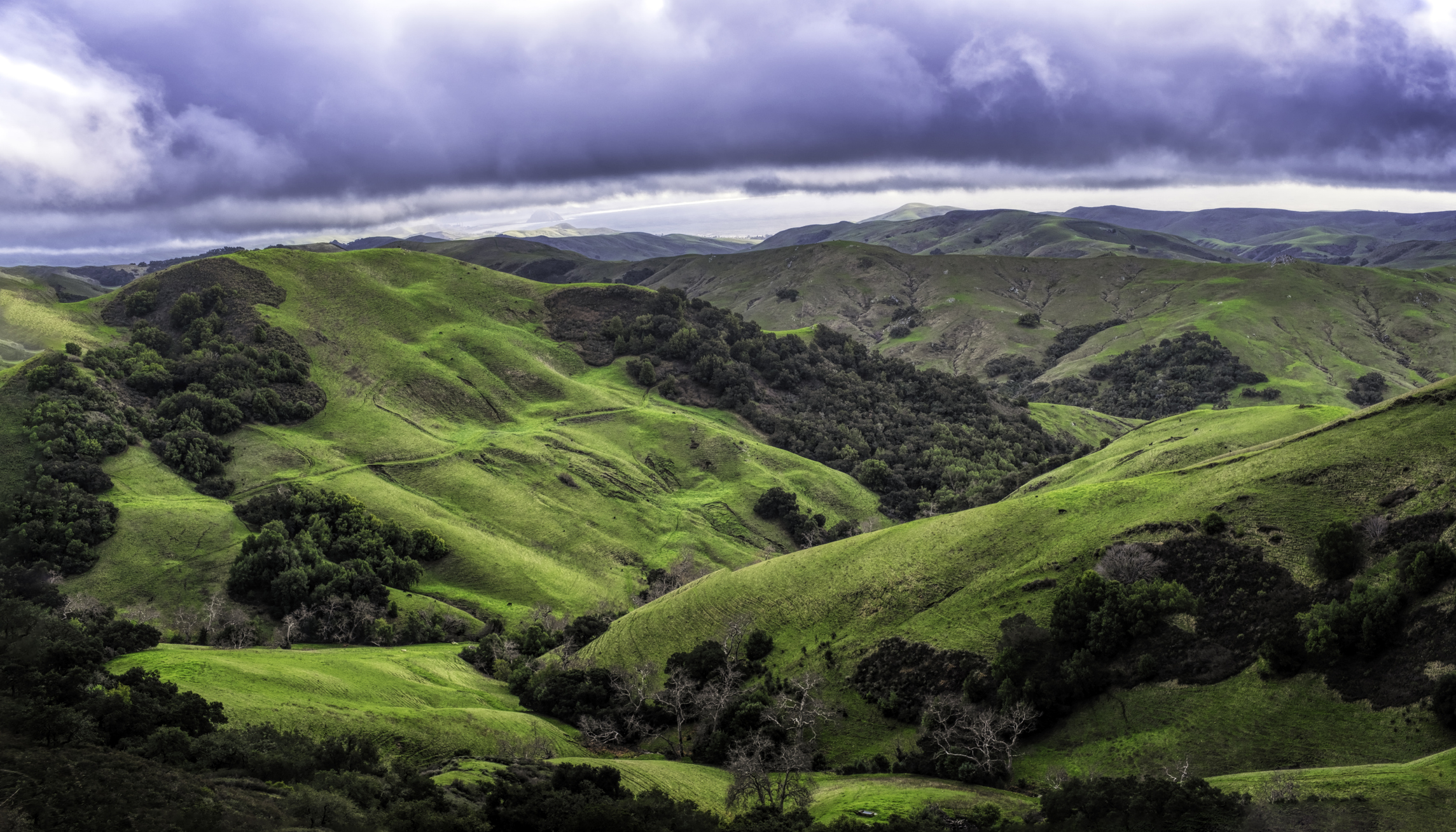 Rolling green hills under a cloudy sky