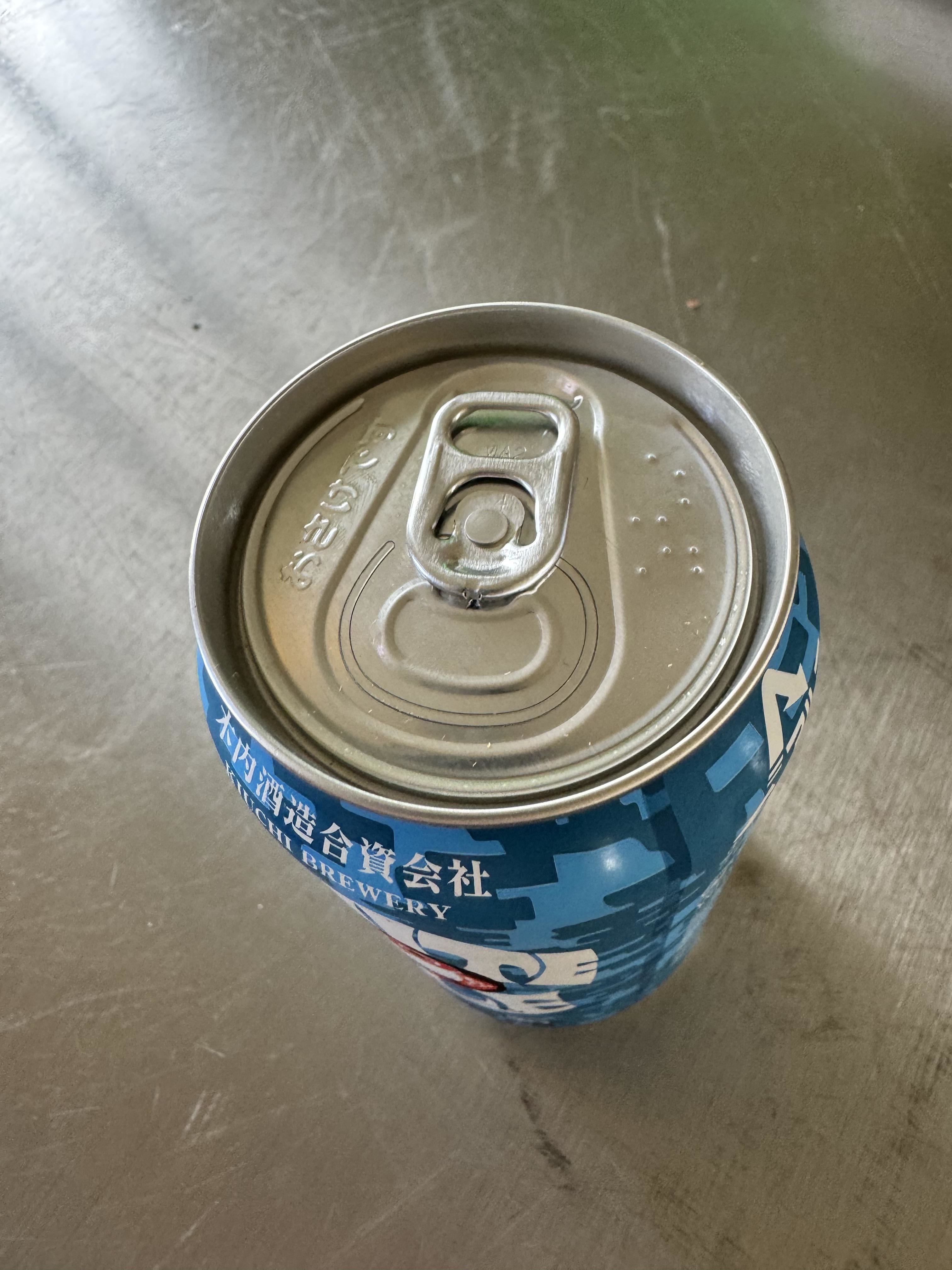 Sealed beverage can with text and graphics, condensation visible on surface