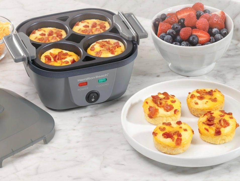 An egg cooker with six egg bites and a bowl of berries, suggesting a cooking time of 10 minutes