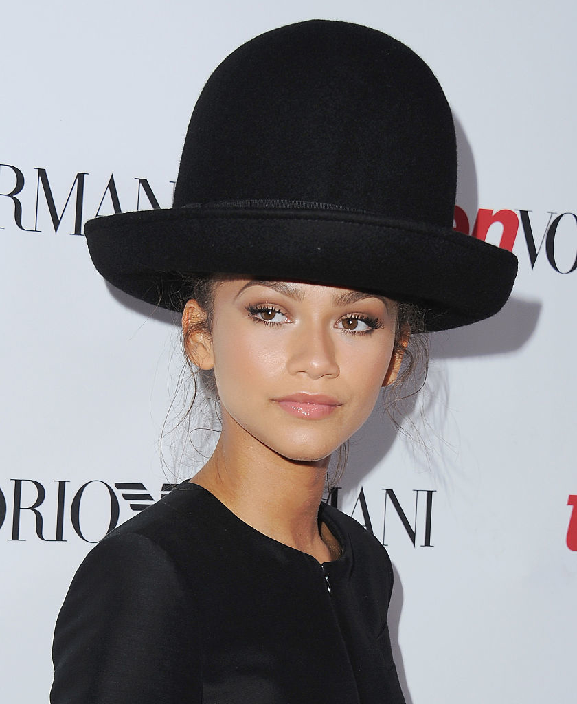 Zendaya in a suit and oversized hat at an event