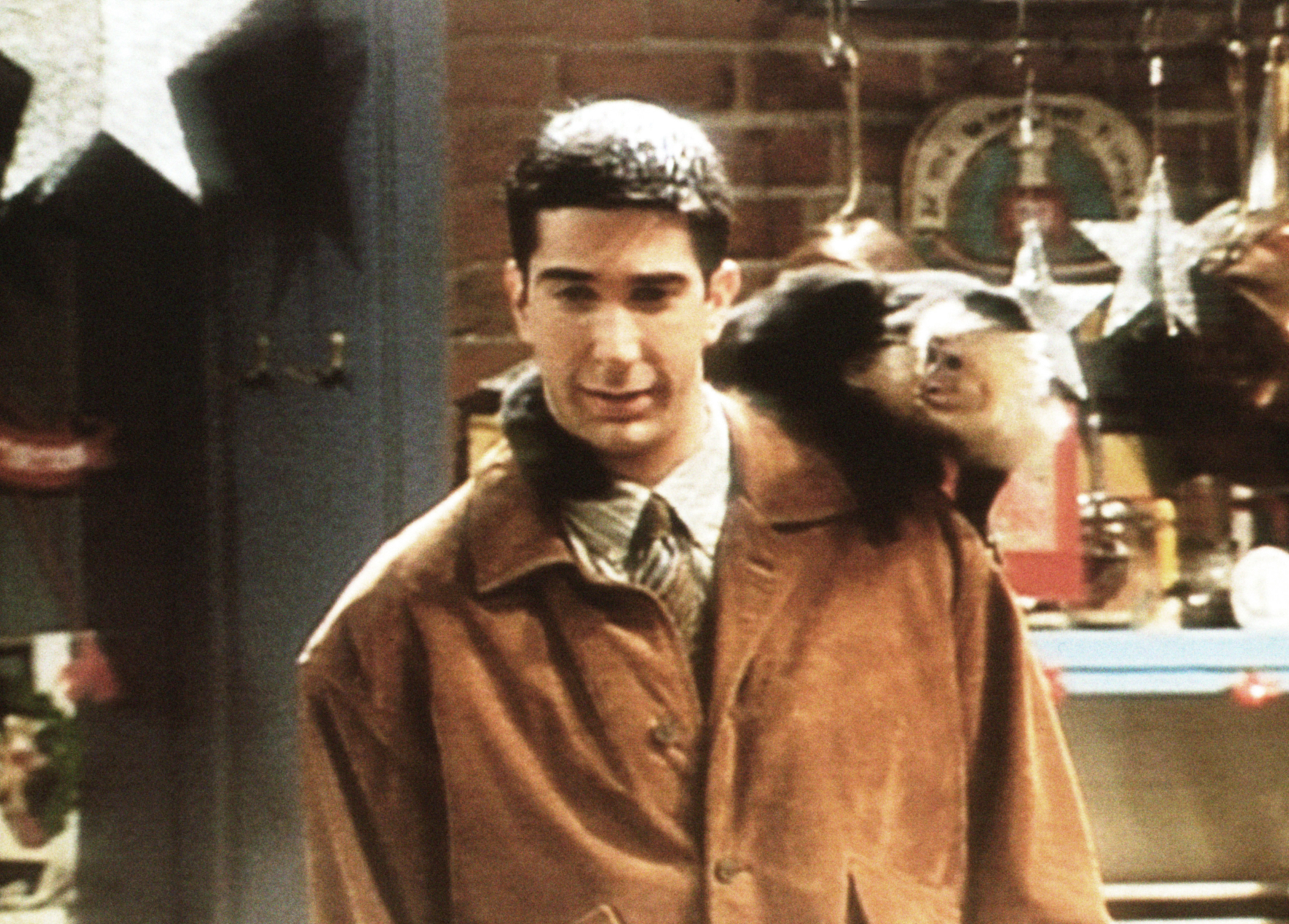 Ross from Friends with Marcel the monkey on his back, in the iconic Central Perk set