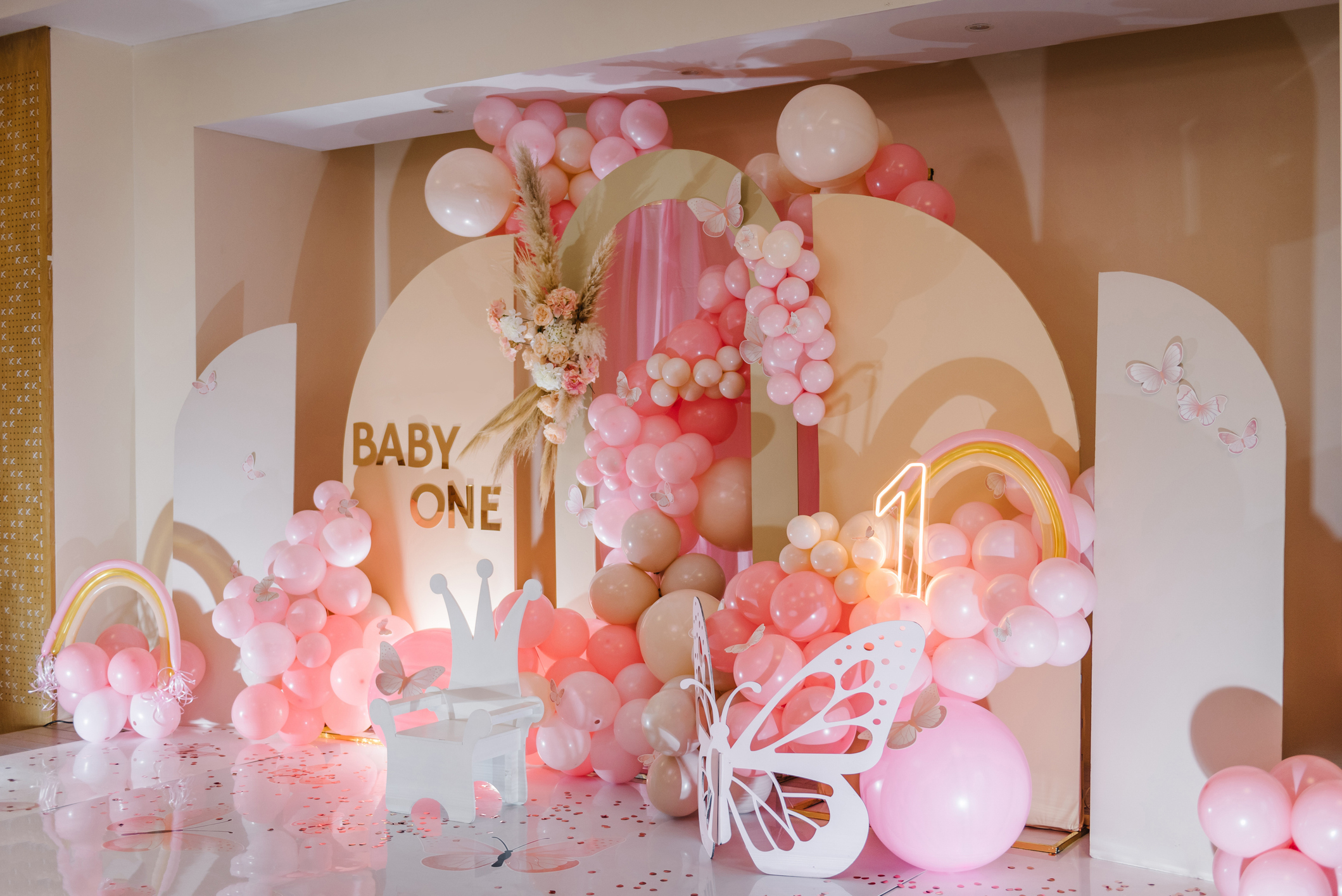 A baby shower decor with balloons, butterfly, and &quot;BABY&quot; sign, no people visible