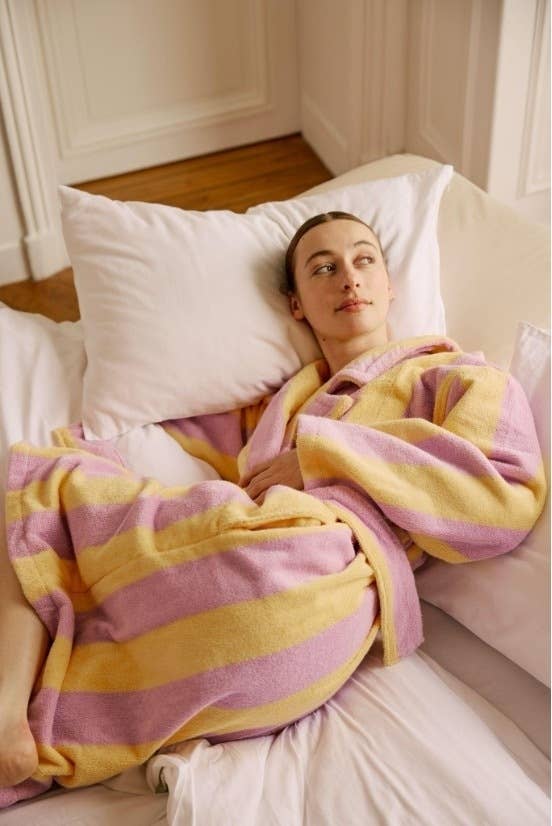 Person lounging in a striped robe, looking relaxed and comfortable for a cozy indoor setting