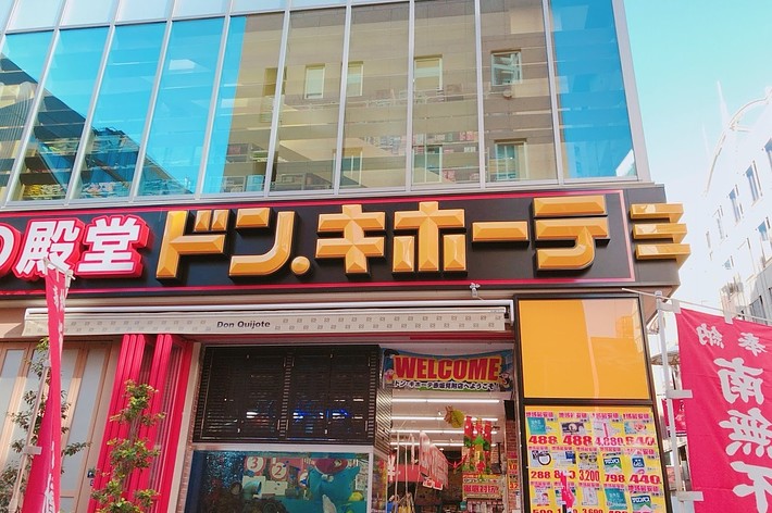 ドン・キホーテの店舗入り口、看板と旗が見える街角の風景