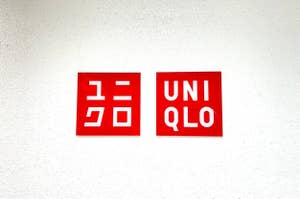 Logos of "GU" and "UNIQLO" in red square frames on a white wall