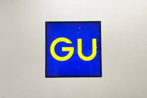 Image of a framed artwork with the letters "GU" displayed in large, bold font against a blue background